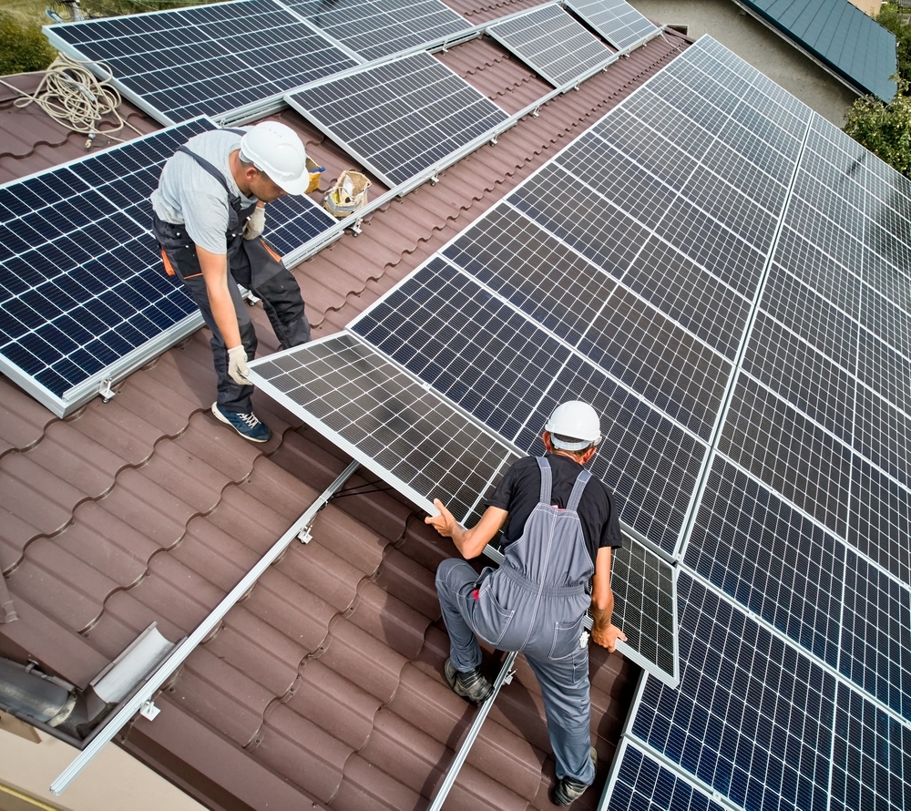 Afbeelding van 2 werkmannen die zonnepanelen installeren