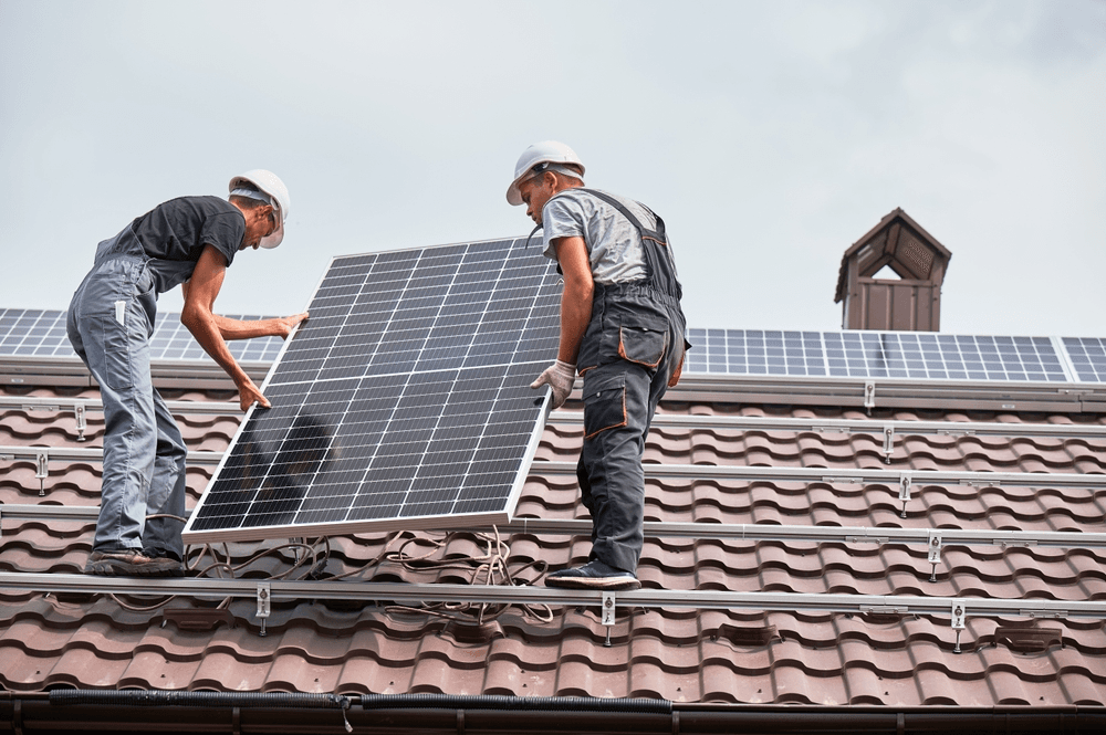 Een Afbeelding van twee techniekers aan het werk. Ze houden beiden een panneel vast